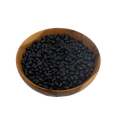 Wooden bowl filled with black turtle beans on a white background