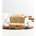 Loaf of bread with a slice cut, on a wooden cutting board with a white background