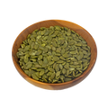 a small wooden bowl with pumpkin seeds on a white background
