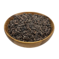 a small wooden bowl with cacao nibs on a white background