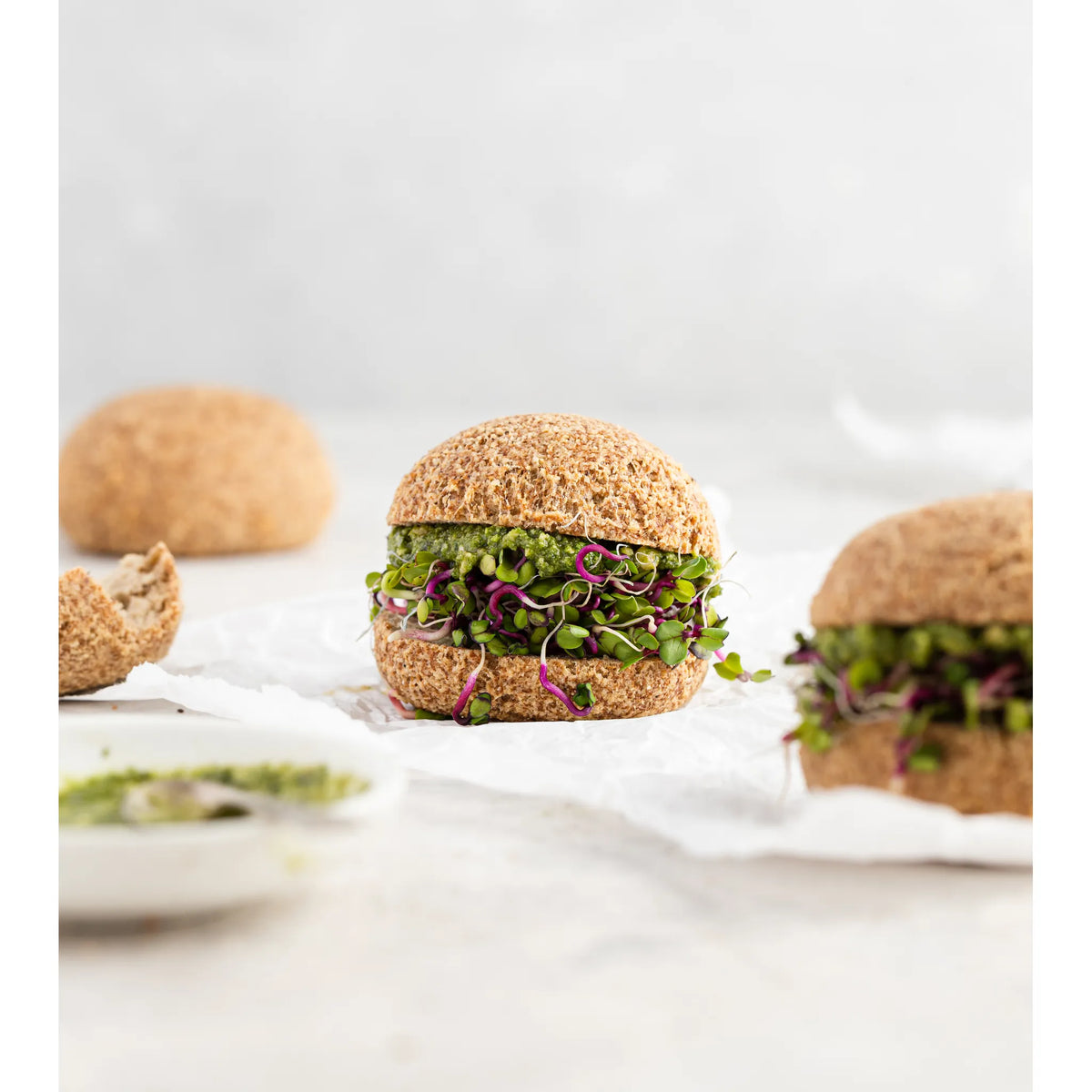 Burger with green toppings on a white background