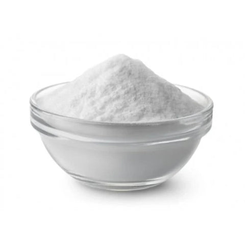 Clear glass bowl filled with  baking soda on a white background