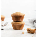 Two stacked muffins on a white surface with a blurred background