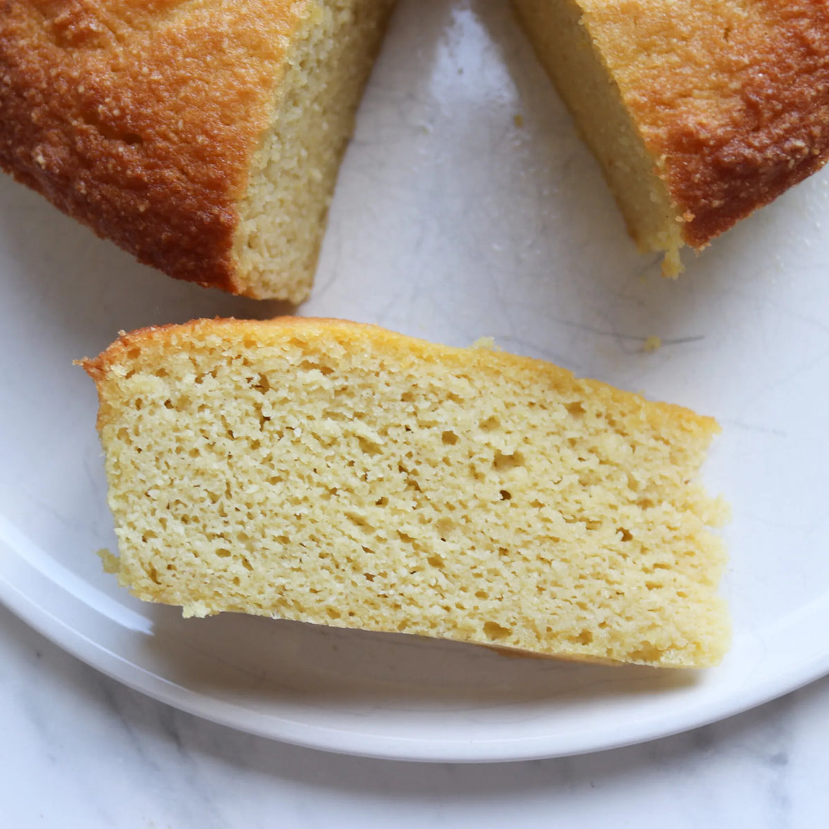 a close up of a slice of Keto Base cake with the main cake on the edge of the photo