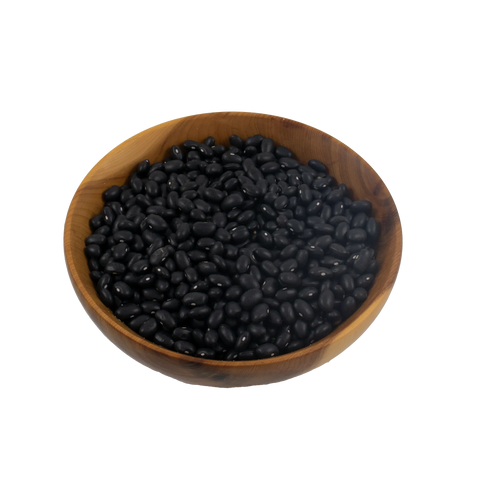 Wooden bowl filled with black turtle beans on a white background