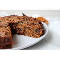 Fruitcake with a slice missing on a white plate