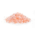 Pile of pink Himalayan salt crystals on a white background