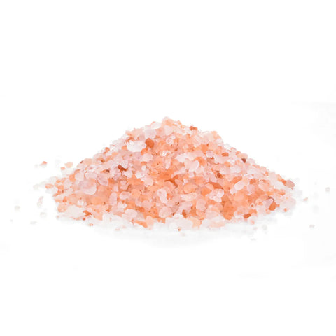Pile of pink Himalayan salt crystals on a white background