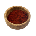 a small wooden bowl with paprika on a white background