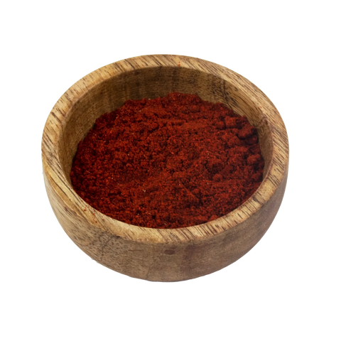 a small wooden bowl with paprika on a white background